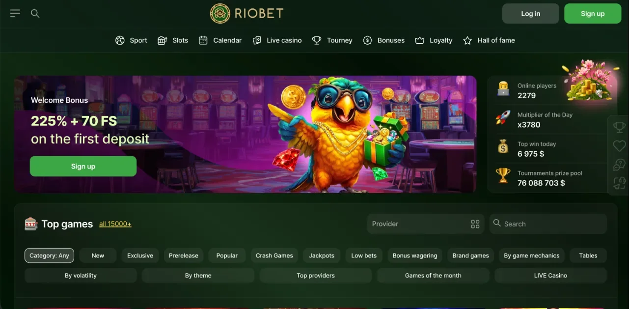 Riobet Casino webes kezdőképernyő pillanatképe a Kaszinók24 főoldali 8. hely értékeléshez: 225% + 70 FS üdvözlő bónusz bannere papagáj karakterrel és Sign up gombbal, arany RIOBET logo, Sport / Slots / Live casino / Tourney / Bonuses / Loyalty főmenü, jobb oldali élő statisztika panel (online játékosok, napi szorzó, top nyeremény, tornadíj összeg), Top games szekció 15 000+ játék felirattal és kategória címkékkel, zöld arany sötét UI (szerkesztőségi illusztráció, 2026).